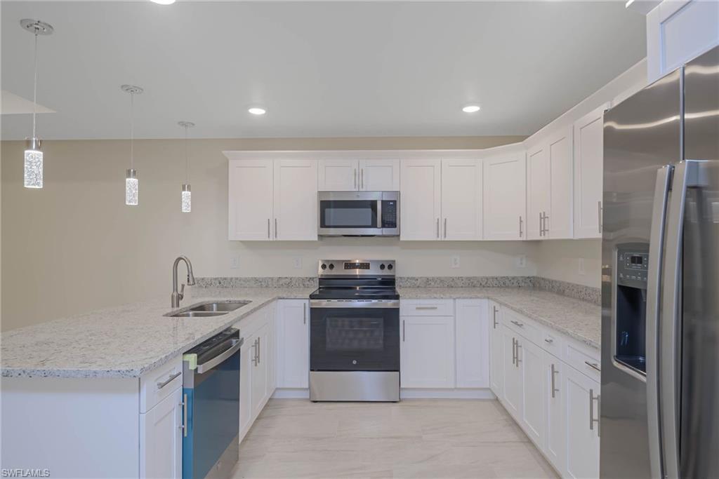 2120 French Street Fort Myers, FL 33916 - Photo 19 of 20 a kitchen with stainless steel appliances granite countertop a stove a sink and a refrigerator