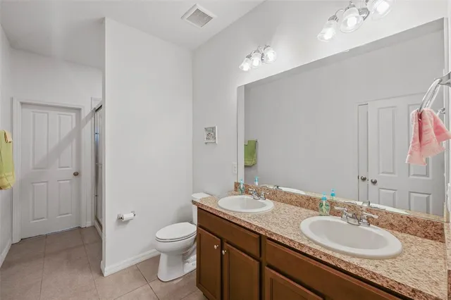 a bathroom with a granite countertop sink a toilet and a mirror
