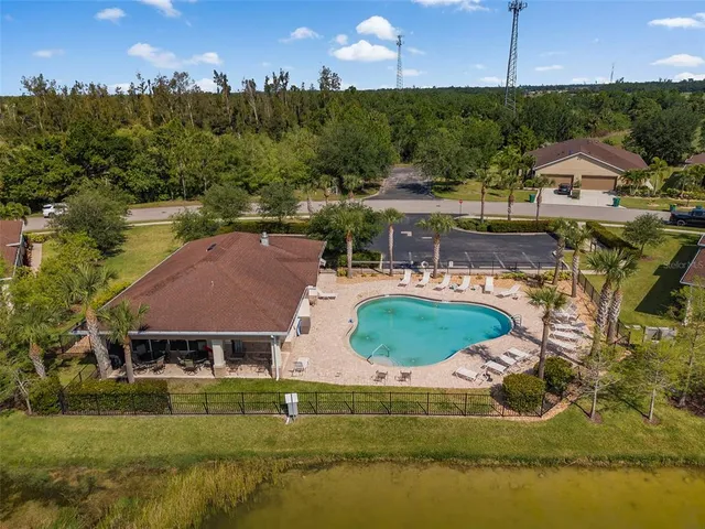 an aerial view of a house with a garden and lake view