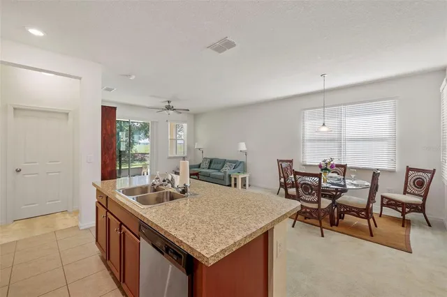 a kitchen with granite countertop a sink and chairs