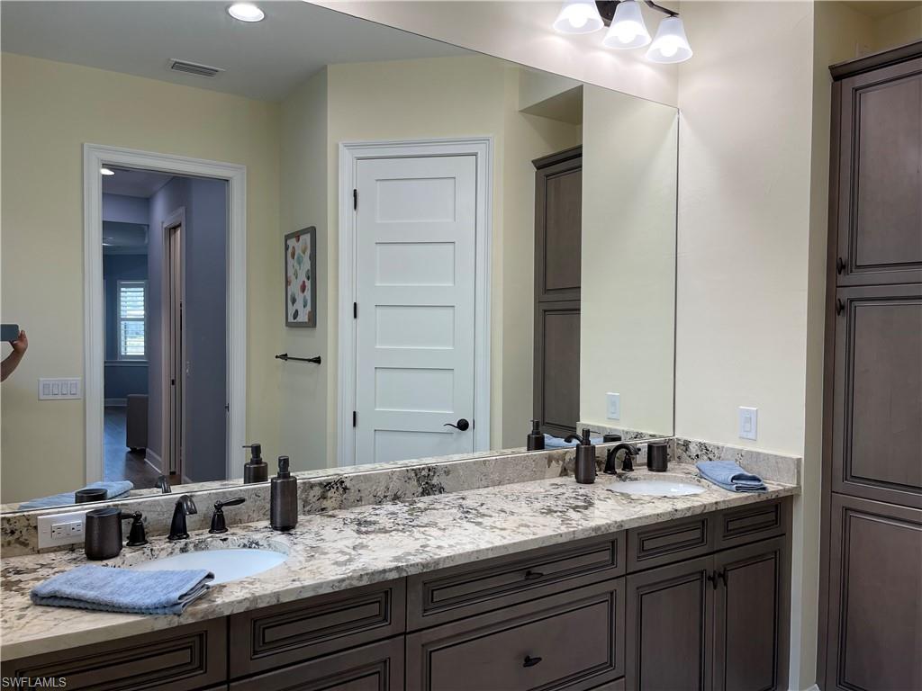 6282 Indies Avenue Naples, FL 34113 - Photo 14 of 33 a bathroom with a granite countertop sink and a mirror