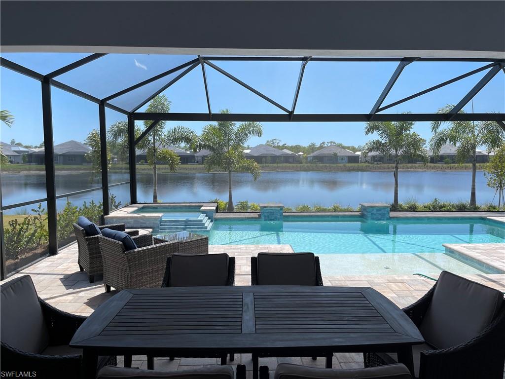 6282 Indies Avenue Naples, FL 34113 - Photo 23 of 33 a view of a patio with table and chairs under an umbrella
