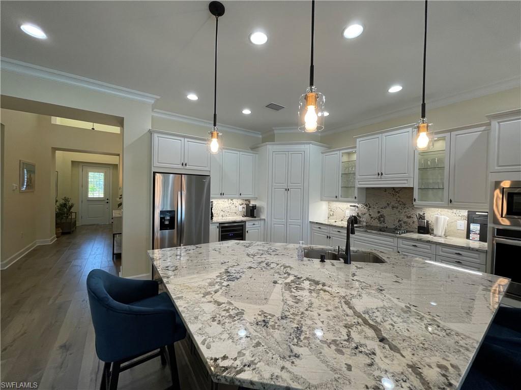 6282 Indies Avenue Naples, FL 34113 - Photo 4 of 33 a kitchen with stainless steel appliances kitchen island granite countertop a sink and chairs