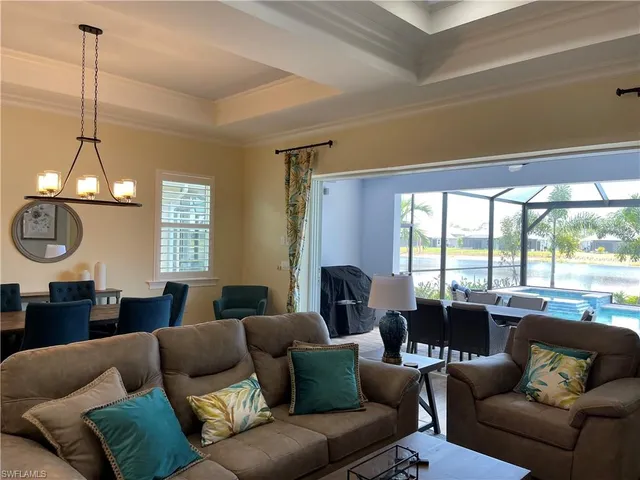 a living room with furniture a chandelier and a large window