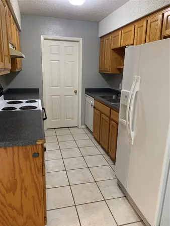 a kitchen with a refrigerator and a stove top oven