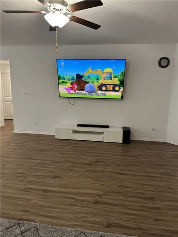 a living room with a flat screen tv and a wooden floor