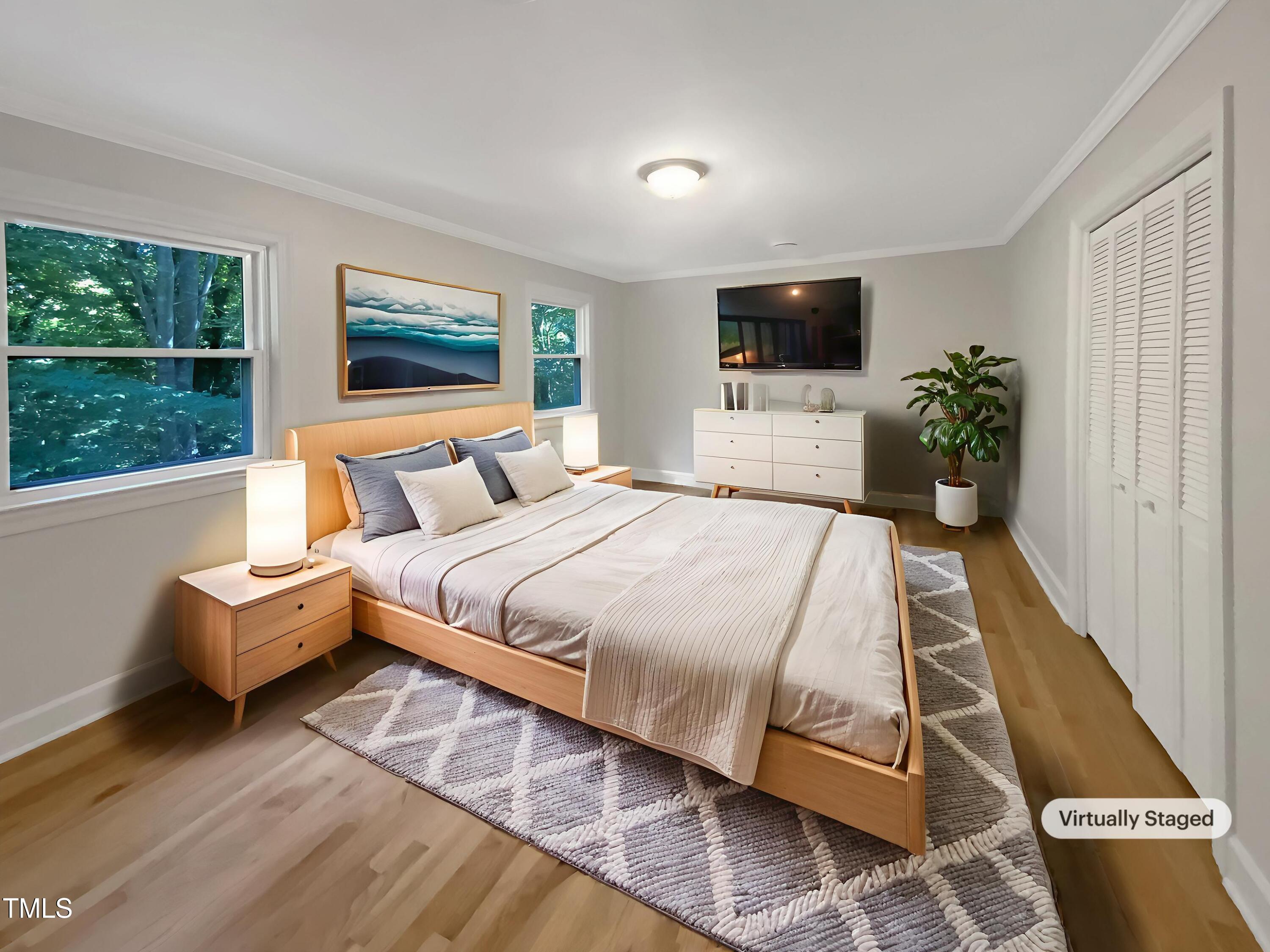 4808 Connell Drive Raleigh, NC 27612 - Photo 4 of 20 a bedroom with a bed and a flat screen tv