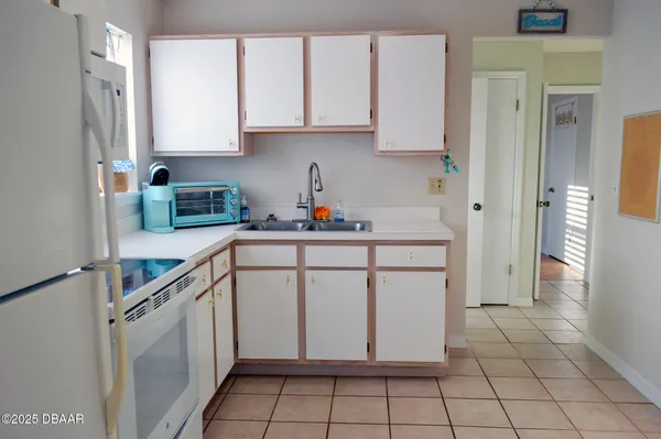 a kitchen with a sink a stove cabinets and a window