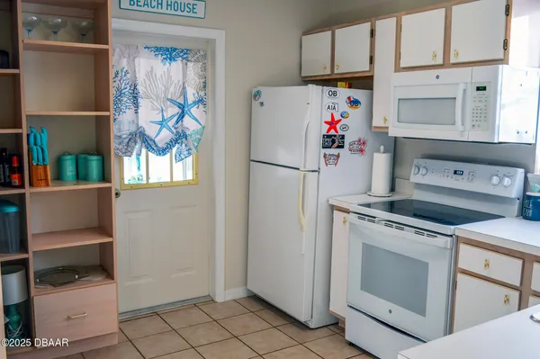 a white refrigerator freezer and a stove sitting inside of a kitchen