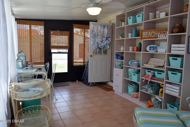 a patio with table and chairs and potted plants