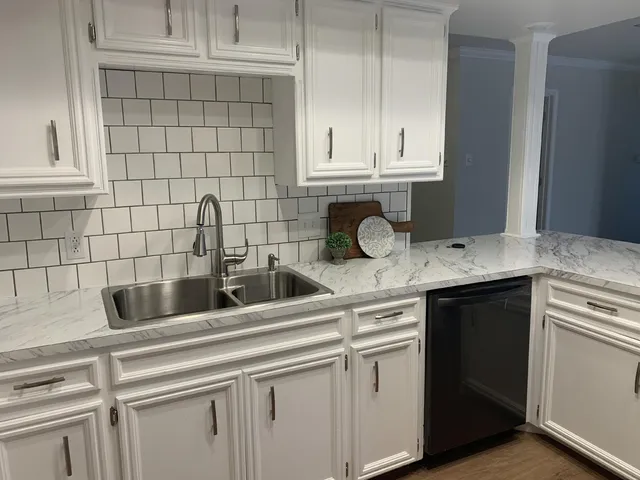 a kitchen with a sink cabinets and a wooden floor