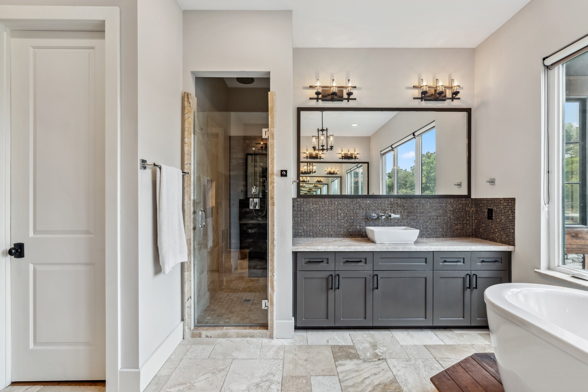 815 East 27th Street Houston, TX 77009 - Photo 23 of 44 The walk-in shower features a rain showerhead, separate handheld sprayer, and a glass shower door for a sleek, modern look. The expansive walk-in closet on the left is a dream, with built-in dressers, shoe storage, and a third row of hanging space with pull-down assists for easy access. There is a private water closet as well.