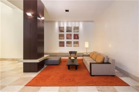 a walk in closet with view of living room