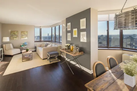 a living room with furniture and a floor to ceiling window