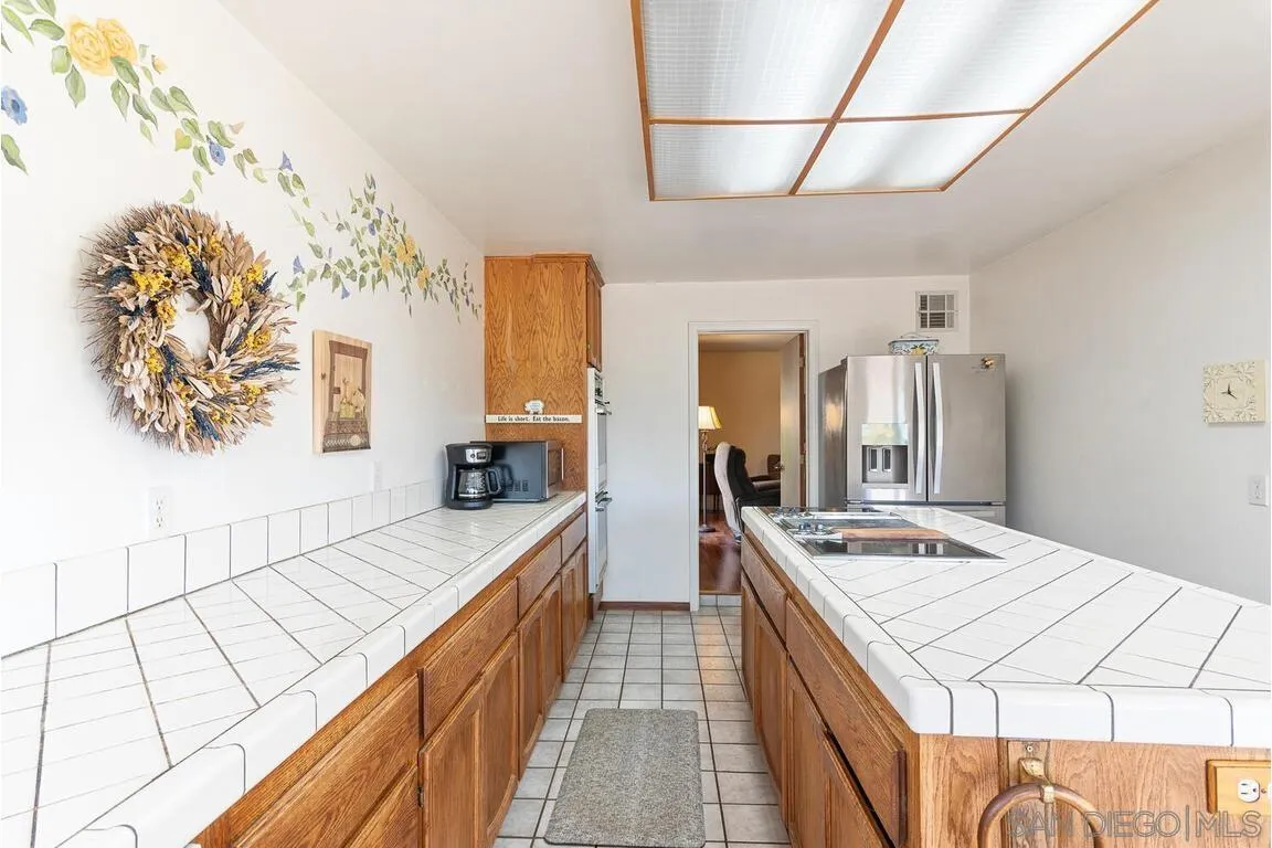 2877 Polk Road Alpine, CA 91901 - Photo 12 of 40 a large kitchen with kitchen island a stove a sink dishwasher and wooden cabinets