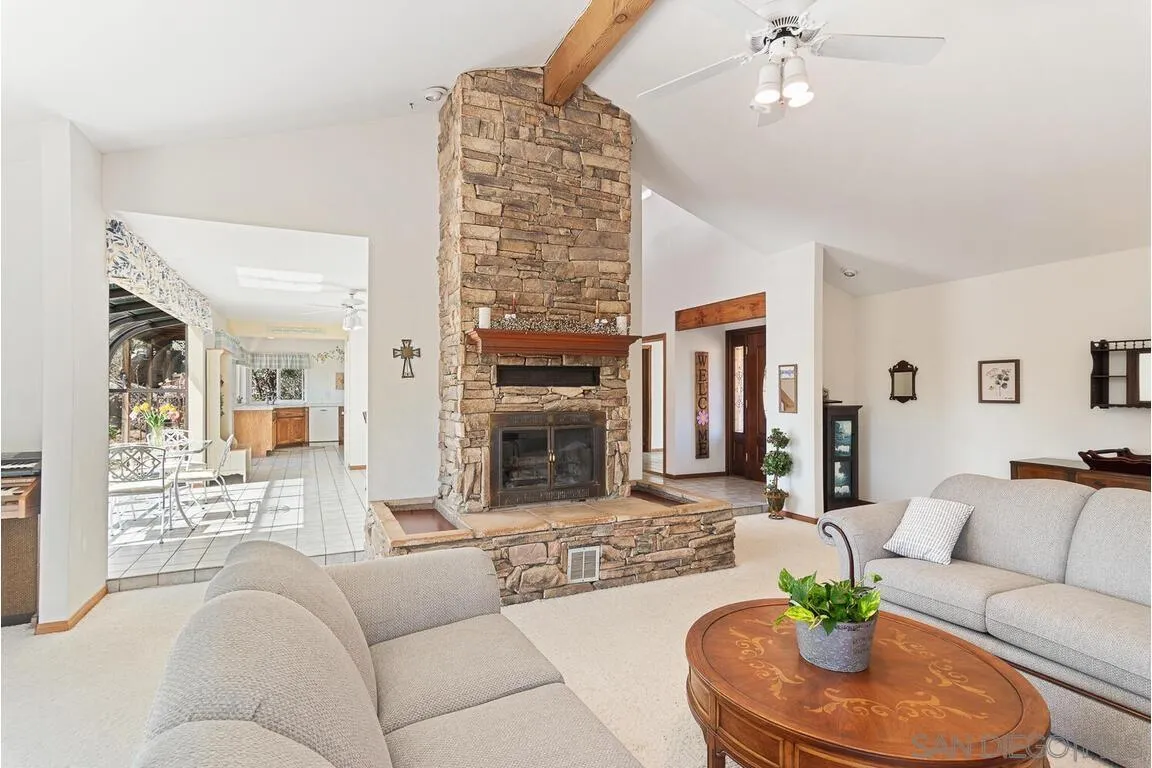 2877 Polk Road Alpine, CA 91901 - Photo 5 of 40 a living room with furniture a fireplace and a chandelier