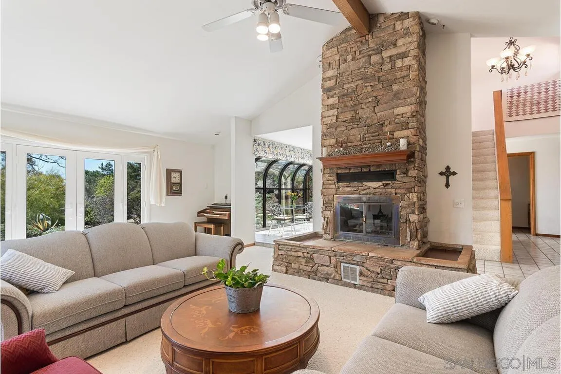 2877 Polk Road Alpine, CA 91901 - Photo 6 of 40 a living room with furniture a fireplace and a chandelier