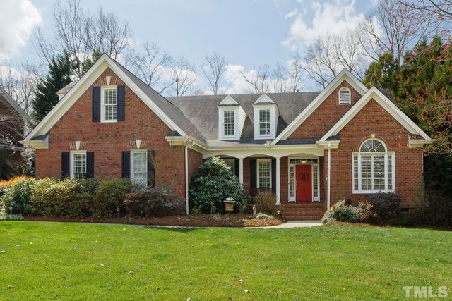 a front view of a house with a yard and potted plants