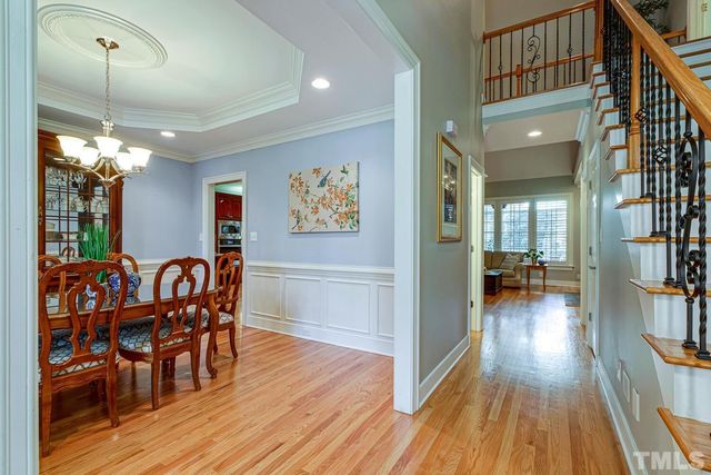 a dining room with furniture a chandelier and wooden floor