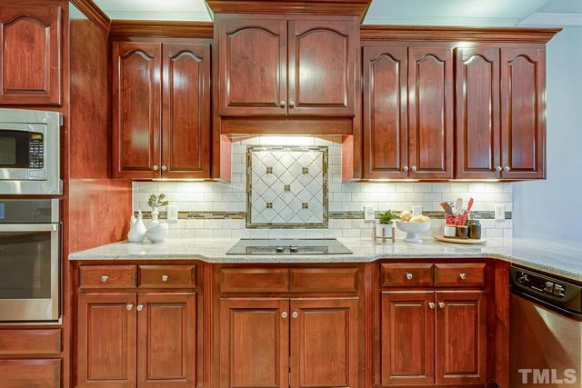 a kitchen with stainless steel appliances granite countertop wooden cabinets and a sink