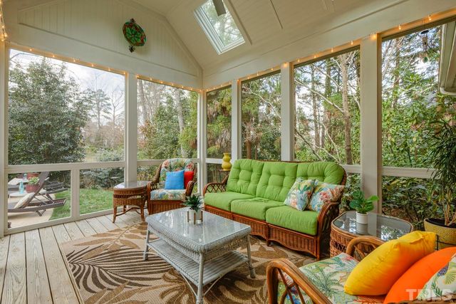 a living room with patio furniture and a floor to ceiling window