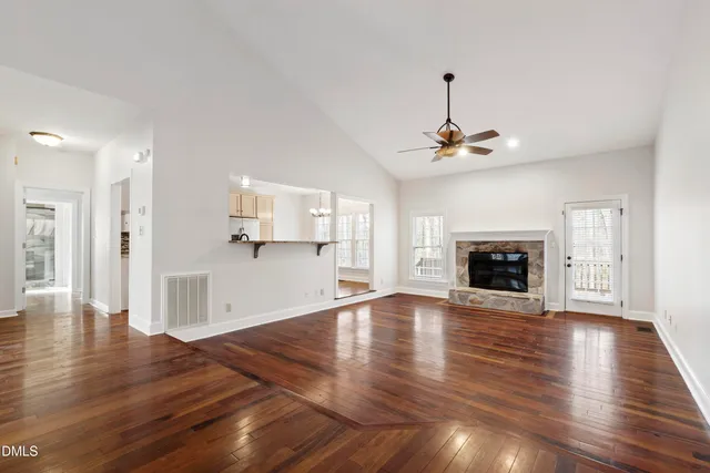a view of empty room with wooden floor and fireplace