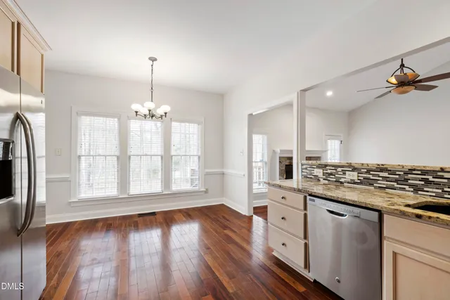 a large kitchen with cabinets wooden floor and a stainless steel appliances