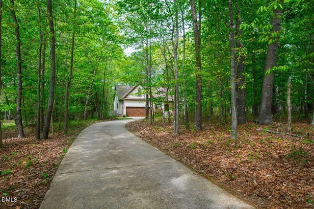 an aerial view of residential house with outdoor space and trees all around