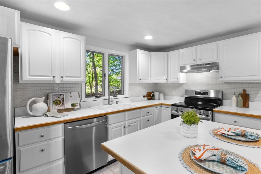40 Cornell Road Beverly, MA 01915 - Photo 10 of 31 a kitchen with stainless steel appliances granite countertop a sink a stove a window and cabinets