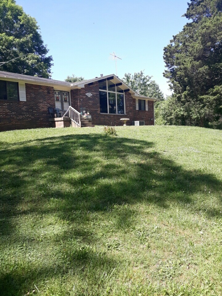 2150 Hogan Road Burns, TN 37029 - Photo 38 of 58 a front view of a house with a yard table and chairs