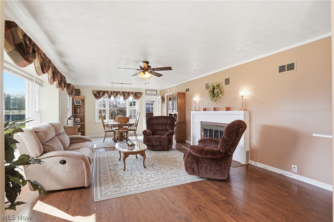 6655 Ceramic Road Crooksville, OH 43731 - Photo 11 of 34 Living area featuring a fireplace, wood finished floors, ceiling fan, and crown molding
