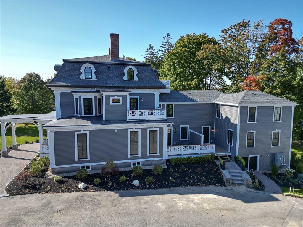 11 Lowell Road, Unit 1A Groton, MA 01450 - Photo 3 of 17 a front view of a house with a garden