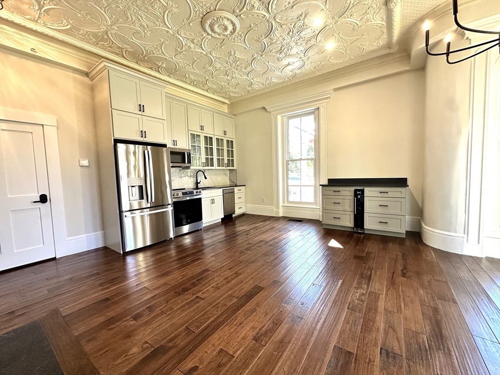 11 Lowell Road, Unit 1A Groton, MA 01450 - Photo 9 of 17 a view of a kitchen with a stove wooden floor and a kitchen