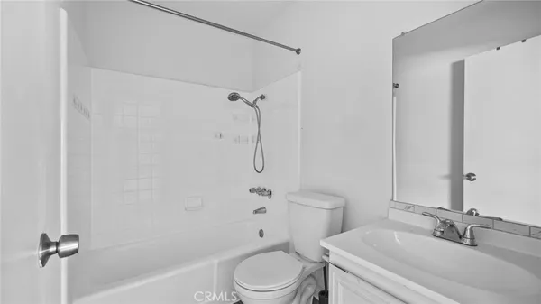 a bathroom with a toilet sink vanity and shower
