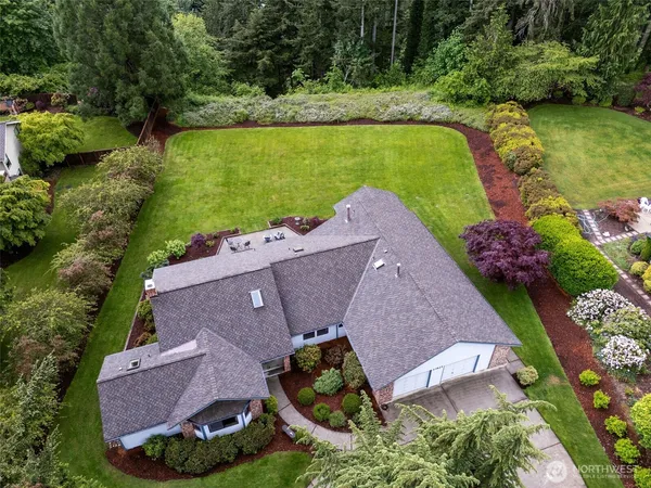 an aerial view of a house with a swimming pool and a yard