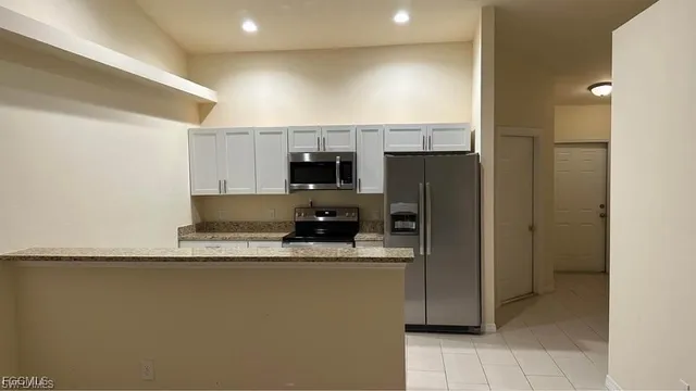 a kitchen with stainless steel appliances granite countertop a refrigerator a stove and a sink