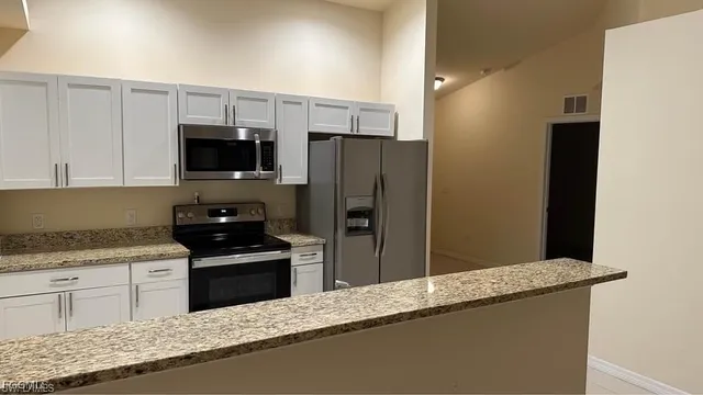 a kitchen with granite countertop a refrigerator and a sink