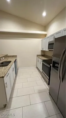 a kitchen with a stove a refrigerator and a cabinets