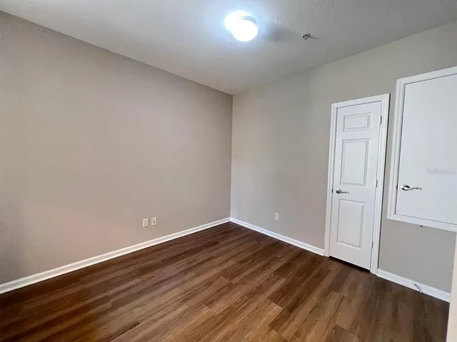 a view of an empty room with wooden floor