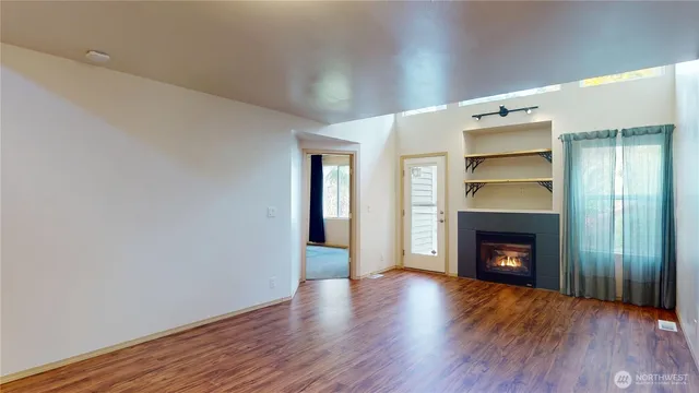 a living room with a fireplace and a wooden floor