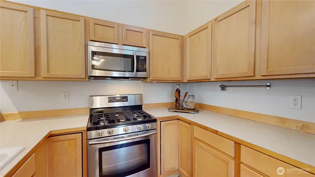 a kitchen with stainless steel appliances a stove a microwave and sink