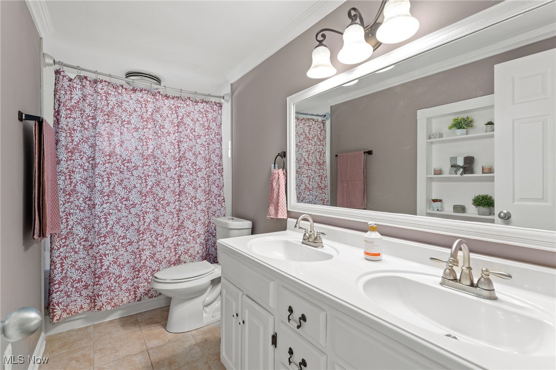 667 High Bridge Road Vermilion, OH 44089 - Photo 23 of 30 Bathroom featuring double vanity, ornamental molding, and light tile patterned floors