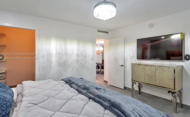 a view of a livingroom with wooden floor and a flat screen tv