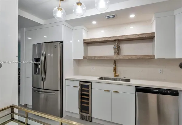 a kitchen with stainless steel appliances a refrigerator and a sink