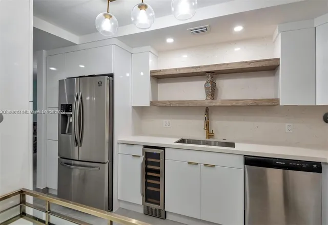 a kitchen with stainless steel appliances a refrigerator and a sink