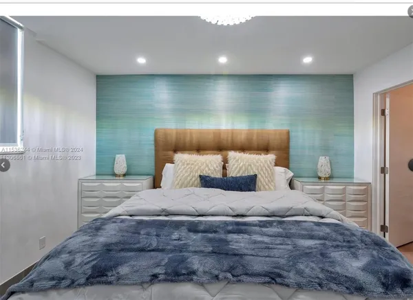 a bedroom with a bed and a large mirror