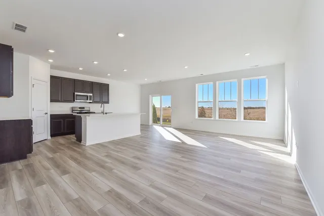 a view of kitchen with granite countertop cabinets and refrigerator