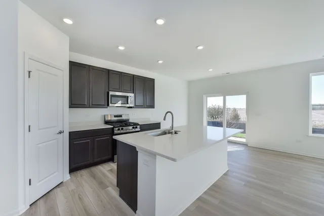 a kitchen with granite countertop a stove top oven and cabinets