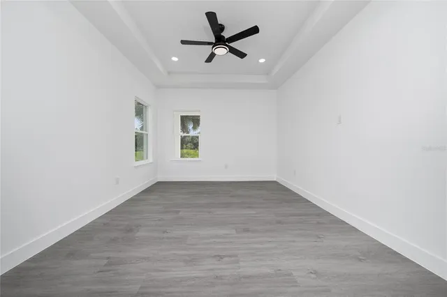 an empty room with a window and a ceiling fan