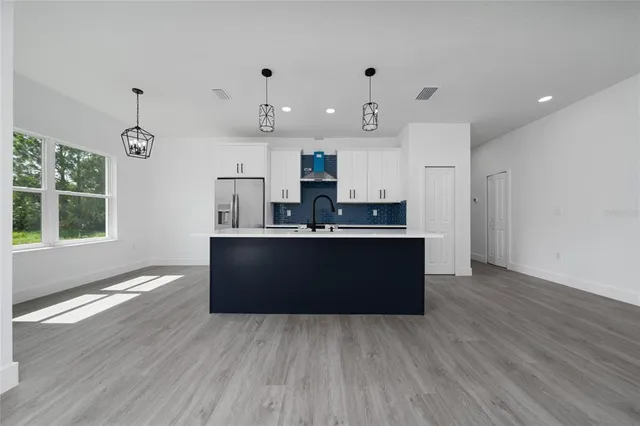 a kitchen with kitchen island a sink dishwasher a stove and a refrigerator with wooden floor